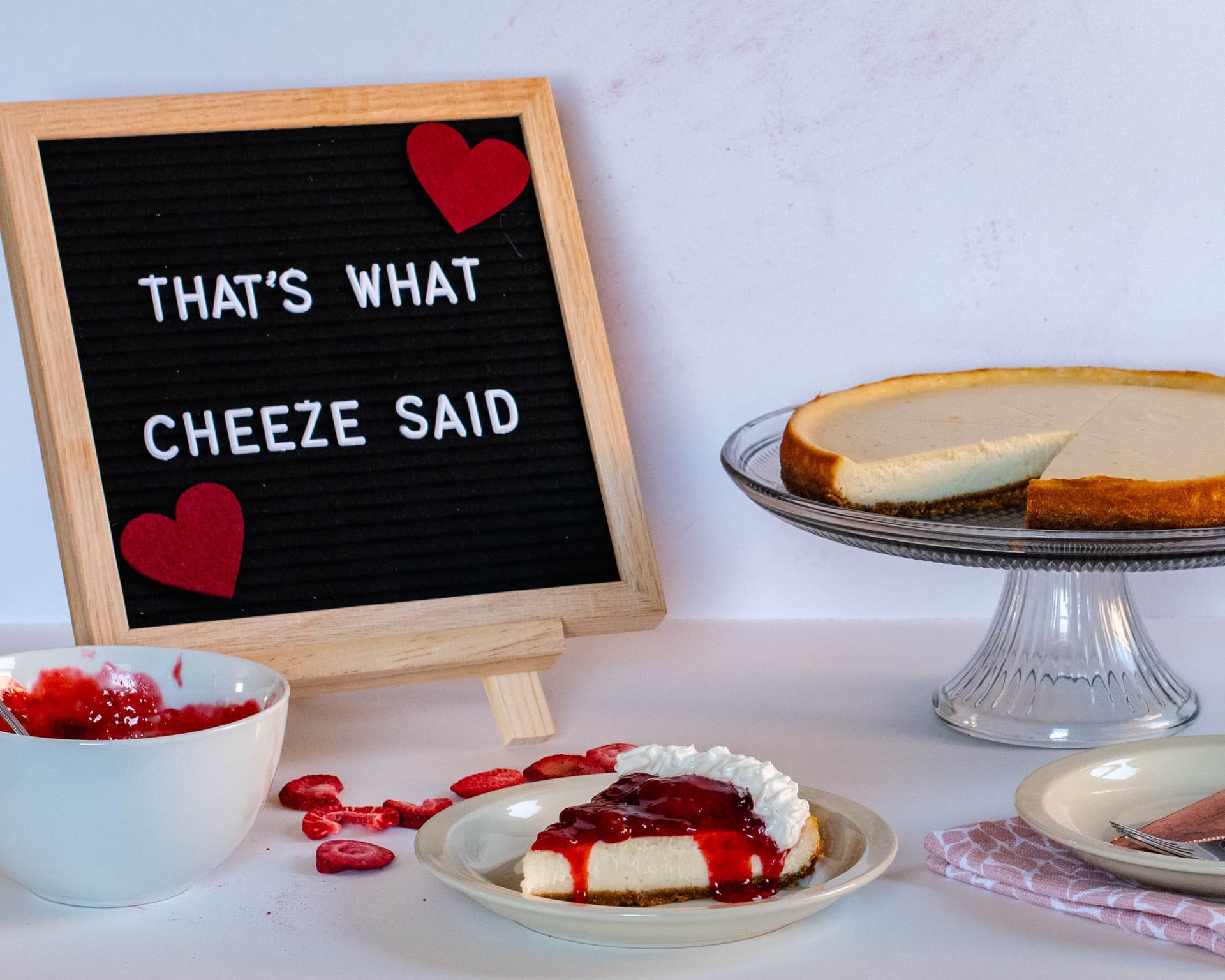 Vegan cheesecake with That's What Cheeze Said sign and strawberry topping