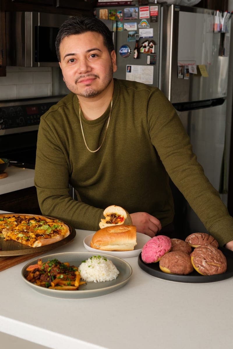 Owner with signature vegan dishes in kitchen