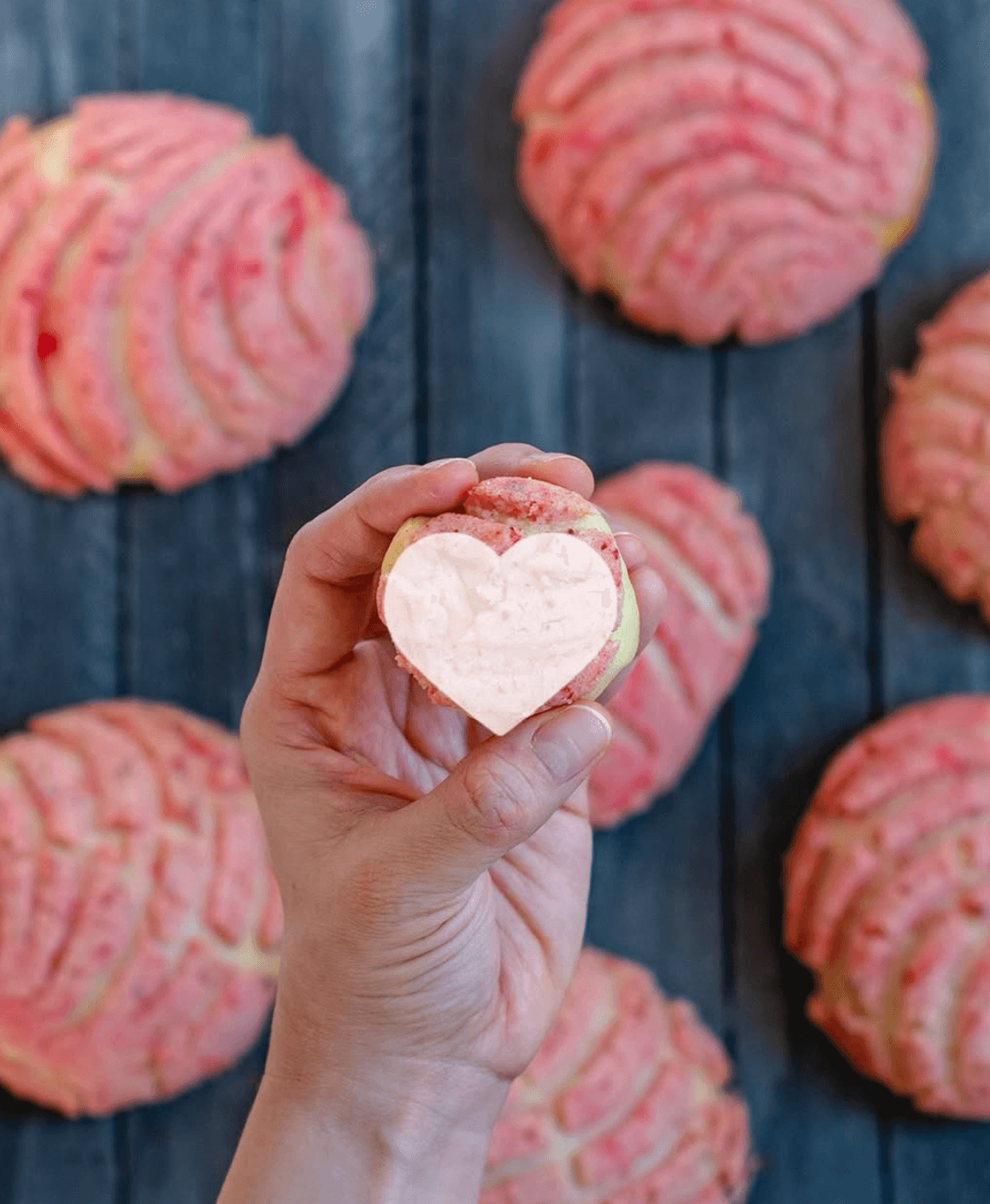 Hand holding a heart-shaped concha